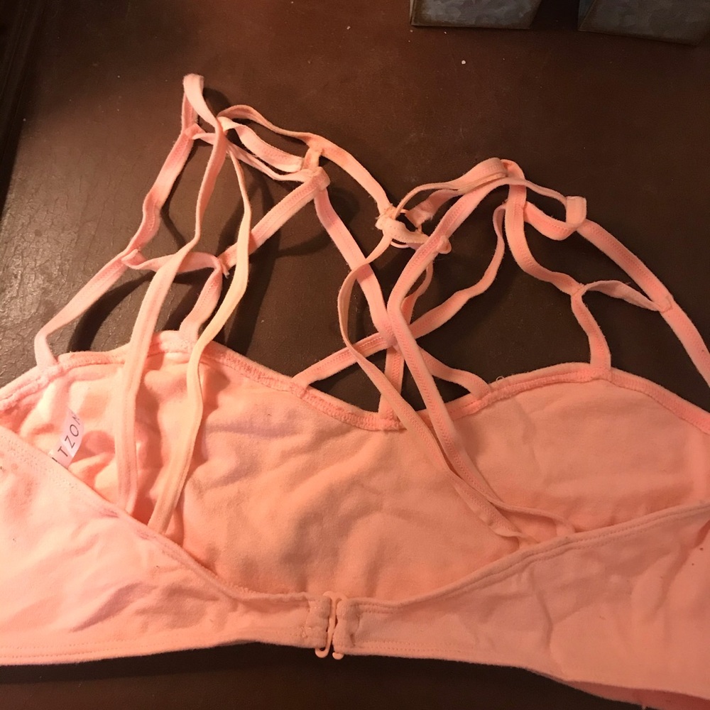 Pink/peachy colored bra that crosses on the chest